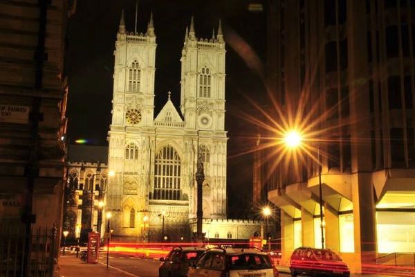 Westminster Abbey illuminated at night, a captivating sight and must-see attraction for visitors exploring London's rich history and architectural wonders.