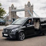 Mercedes-Benz V-Class with a professional driver and an open passenger door parked near Tower Bridge in London